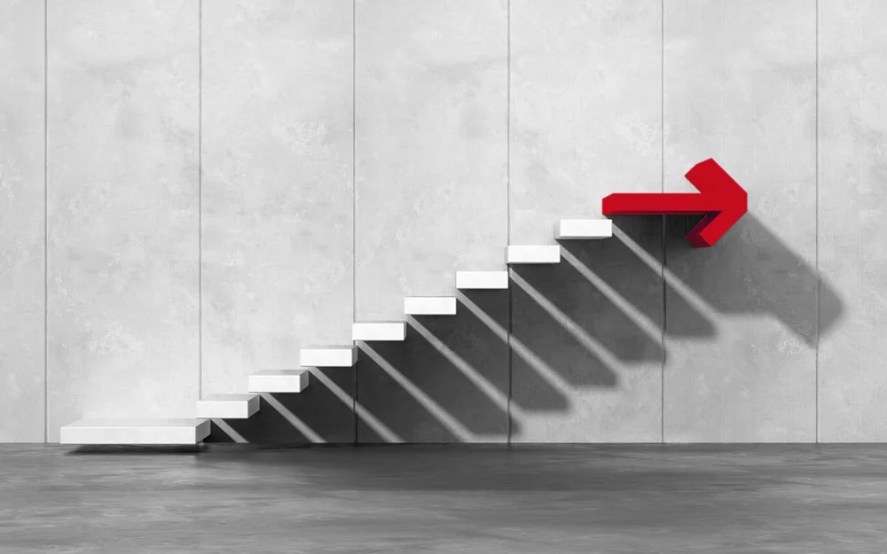 Eine Treppe, die von einem Pfeil nach oben begleitet wird, der auf den nächsten Abschnitt hinweist.